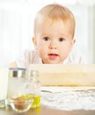 Little baby girl is cooking, kneads dough baking