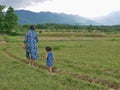 A little baby girl, daughter, following her mother footsteps in rural area in Thailand
