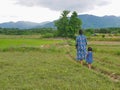 A little baby girl, daughter, following her mother footsteps in rural area in Thailand