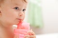 Little baby girl drinks juice from a bottle Royalty Free Stock Photo