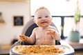 Little baby girl eating her spaghetti dinner and making a mess