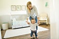 Little baby girl first steps with the help of mother