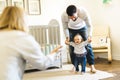 Little baby girl first steps with the help of parent