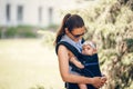 Little baby girl and her mother walking outside babywearing in the ergo carrier concept Royalty Free Stock Photo