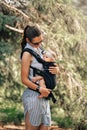 Little baby girl and her mother walking outside babywearing in the ergo carrier concept Royalty Free Stock Photo