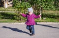 Little baby girl in jeans jacket and hat making learning to walk his first steps on the lawn in the green grass Royalty Free Stock Photo