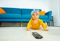 Little baby girl lay on the floor with tv control