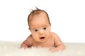 Little baby girl Lying on her belly on a sheepskin and holding h Royalty Free Stock Photo