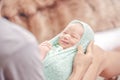 Little baby girl one week in green blanket on mother lap smiling to her mother. Baby clothes changing Royalty Free Stock Photo