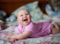 A little baby girl in pink clithes lying at home on the bed Royalty Free Stock Photo