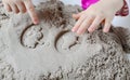 Little baby girl playing with kinetic sand