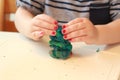 Little baby girl are playing with play dough. Mixes the colors. Girl with pink polish. Play with clay.