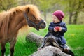 Little baby girl with red apple and pony Royalty Free Stock Photo