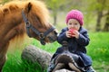 Little baby girl with red apple and pony Royalty Free Stock Photo