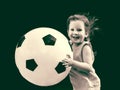 Little baby girl runs with a huge soccer ball. Royalty Free Stock Photo