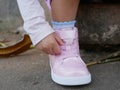 Little baby girl`s hand trying to arrange shoelace by herself