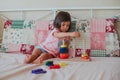 Little baby girl sitting on the bed and playing Royalty Free Stock Photo