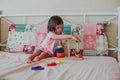 Little baby girl sitting on the bed and playing Royalty Free Stock Photo