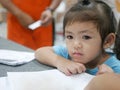 Little baby girl sitting and feeling tedious / bored waiting for her parents to do shopping at a shopping mall