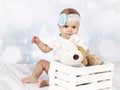 Little baby girl sitting on the floor with box of plush toys Royalty Free Stock Photo