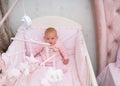 Little baby girl sitting in her crib.