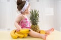 Little baby girl sitting on table with fruits Royalty Free Stock Photo