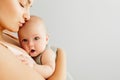 A little baby girl smiles and plays on the bed with her mom Royalty Free Stock Photo