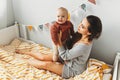 A little baby girl smiles and plays on the bed with her mom Royalty Free Stock Photo