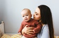 A little baby girl smiles and plays on the bed with her mom Royalty Free Stock Photo