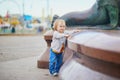 Little baby girl standing close to city fountain on a street of Helsinki, Finland Royalty Free Stock Photo