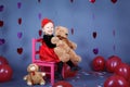 Little baby girl toddler sitting on small pink chair with bear toy in studio Royalty Free Stock Photo