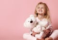 Little baby girl toddler sitting  with white polar teddy bear happy smiling on pink Royalty Free Stock Photo