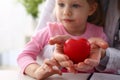 Little baby girl visiting doctor holding in hands red toy heart Royalty Free Stock Photo