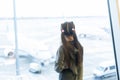 little baby girl waiting boarding to her flight in airport transit hall and looking at airplane parking near departure Royalty Free Stock Photo