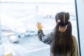 little baby girl waiting boarding to her flight in airport transit hall and looking at airplane parking near departure Royalty Free Stock Photo