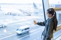 little baby girl waiting boarding to her flight in airport transit hall and looking at airplane parking near departure Royalty Free Stock Photo