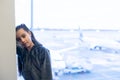 little baby girl waiting boarding to her flight in airport transit hall and looking at airplane parking near departure Royalty Free Stock Photo