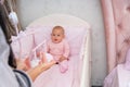 Little baby girl watching a hanging mobile.