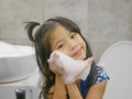 Little baby girl, 4 years old, enjoys making soap foam / bubbles in a bathroom at home - children and a bubble bath Royalty Free Stock Photo