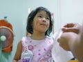 Little baby girl, 3 years old, get caught for putting on / using her mom`s cosmetics - child playing make up Royalty Free Stock Photo