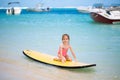 Little baby girl - young surfer with bodyboard has a fun on small ocean waves. Royalty Free Stock Photo