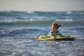 Little baby girl young surfer with bodyboard has a fun on small ocean waves. Active family lifestyle Royalty Free Stock Photo