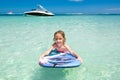 Little baby girl - young surfer with bodyboard has a fun on small ocean waves. Active family lifestyle. Royalty Free Stock Photo