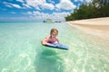 Little baby girl - young surfer with bodyboard has a fun on small ocean waves. Active family lifestyle. Royalty Free Stock Photo