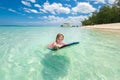 Little baby girl - young surfer with bodyboard has a fun on small ocean waves. Active family lifestyle. Royalty Free Stock Photo