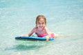 Little baby girl - young surfer with bodyboard has a fun on small ocean waves. Active family lifestyle. Royalty Free Stock Photo