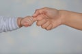 Little baby holding mother`s finger on light background Royalty Free Stock Photo