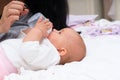 Little baby learning to feed itself from a bottle.