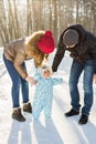 Little baby learning to walk. Mother and father with toddler boy at the winter park Royalty Free Stock Photo