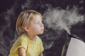 Little baby looks at the humidifier Royalty Free Stock Photo